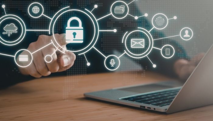 A person points to a digital lock icon among cybersecurity symbols