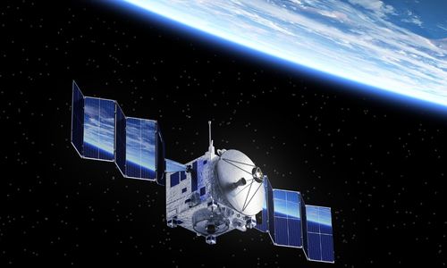 A satellite with large solar panels orbits Earth against a backdrop of stars and space